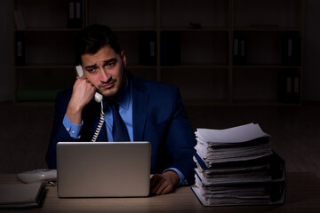 Young male employee working late in the office