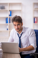 Young male employee and too much work in the office