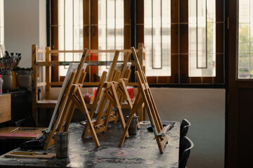 Interior of the creative art workshop with wooden easels and painting equipment 