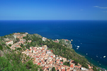 Fototapeta na wymiar Photograph of the coast of Taormina in Sicily, houses, boats and trees.