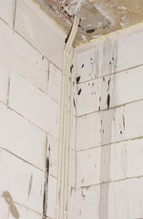 Electrical wiring on new house construction wall. Electric hidden wires installation on aereted concrete wall.