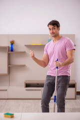 Young male contractor cleaning the house