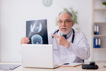 Old male doctor radiologist working in the clinic