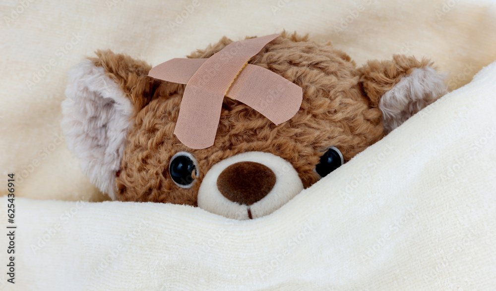 Canvas Prints Sick teddy bear toy with patch in on head lying in bed