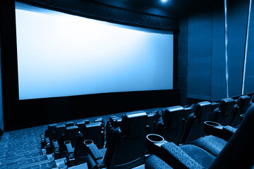 Dark movie theatre interior with screen and chairs
