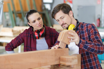 carpenter man and woman working in workshop as a team