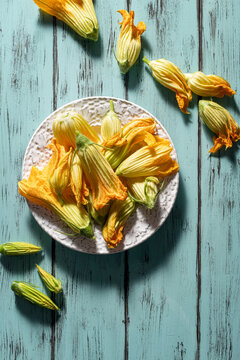 Zucchini flower on delicate pastel wooden background.