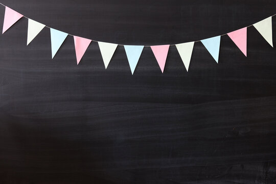 a blackboard with a pastel flags garland background
