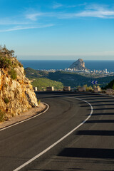 Empty winding mountain road, Calpe village at background, Alicante, Costa Blanca, Spain