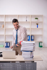 Young male employee unhappy with excessive work in the office