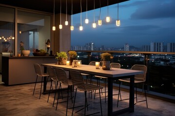 Bar chairs with a trendy design placed around a concrete table, situated beneath dangling light bulbs on wires, on the balcony of an apartment in a condominium.