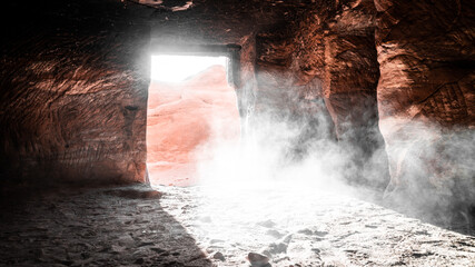 inside of petra jordan cave with sun shining inside and dust