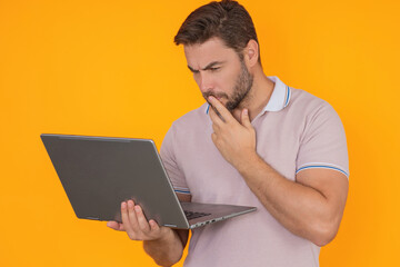 Man using laptop. Man worker watch video on computer laptop. Serious man hold laptop computer. Caucasian man in glasses work with laptop, studio isolated portrait.