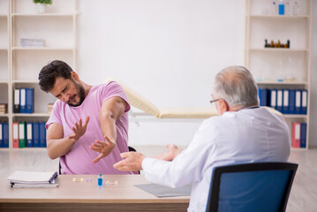 Obraz premium Young male patient visiting old male doctor