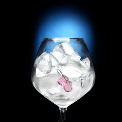 pink earrings in a glass with ice on blue background