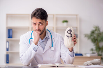 Young male doctor in remuneration concept