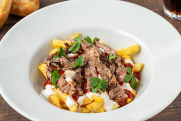Turkish food Çökertme Kebab. Kebab made with thinly sliced beef steak on french fries and yoghurt