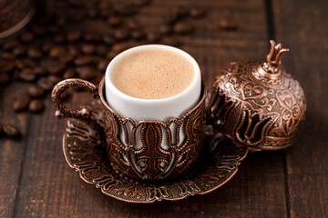 Turkish coffee in classic coffee cup with water and Turkish delight on wooden table