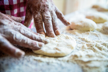 Cooks dough for baking, pieces of raw dough. Womans hands rolling doughs for pies. Baking at home....