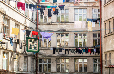 Washed clothes drying. Fresh clean clothes are drying outside. Clothes hanging to dry on a clothes-line. Laundry dryings on the rope. Washed clothes drying outside of an old house