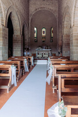 Fototapeta na wymiar Interno di una chiesa addobbata con fiori e fiocchi per matrimonio religioso
