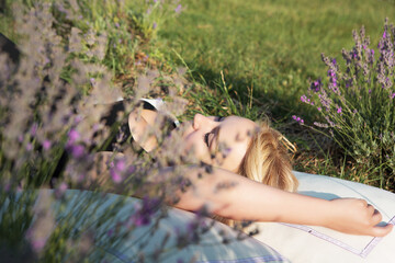 Young beautiful woman sleeps on a pillow in a lavender field. Healthy sound sleep.