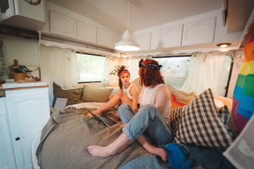 Portrait of a cute lesbian couple. Two girls spend time tenderly together in a camper trailer. Love and attitude. LGBT concept