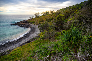 Fototapeta na wymiar sunset over a beautiful cameral hidden little cove bay covered with greenery in Noosa National Park, Queensland, Australia 
