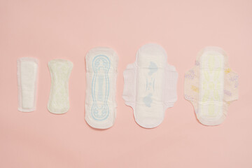 Different feminine sanitary napkins (sanitary pads) on pink background