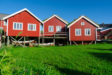 Obraz premium Norway. Fishermans red rorbu cottage in the Lofoten Islands. Typical Scandinavian Fishermans house. now days popular tourist apartments, cottages, rent houses.