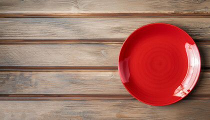 An empty red plate on a rustic wooden table top background
