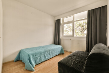 a bedroom with a bed, couch and window in the corner to the left is an image of a tree outside view