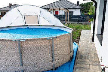 A large expansion pool with a diameter of 3.96 m, set in the yard next to the house, covered with a...