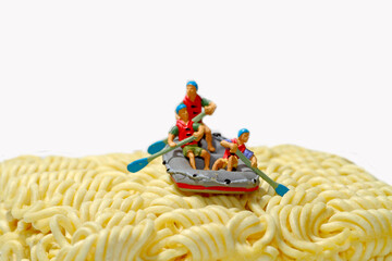 concept miniature figure, rowers rowing on noodles