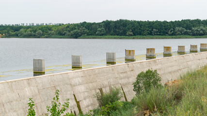 River dam. Dam. Close-up of the dam. Concrete pillars in the water near the dam