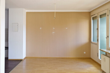 Unrenovated room in a 1970s apartment with the original and outdated windows, seventies style. Empty rental aparment after the tenants have moved out.