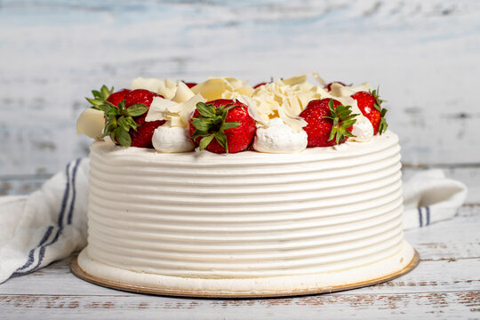 Strawberry and white chocolate cake. Fruit and cream cake on wood background. Close up
