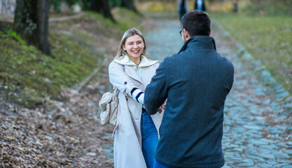 Obraz premium Portrait of a couple walking in the park holding hands while laughing.