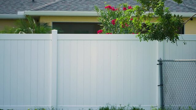 White plastic fence for back yard protection and privacy. Vinyl plank fencing in Florida