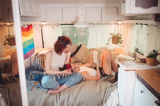Portrait of a cute lesbian couple. Two girls spend time tenderly together in a camper trailer. Love and attitude. LGBT concept