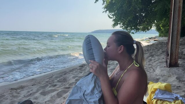 happy smiling woman inflate inflatable ring to swim at the sea summer vacation