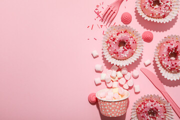 Donuts, jelly candies and marshmallows on pink background, space for text