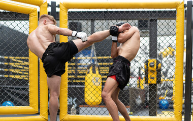 Two male athlete boxing competition in ring. Diverse ethnic men punch fighting in kickboxing exercise in fitness gym. Boxing is fighter sport training need body strength and power fist to knockout.