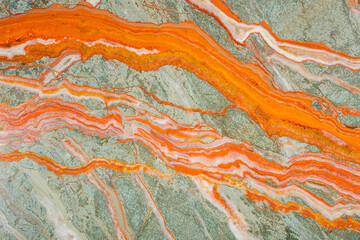 The unique texture of Onyx, bright saturated streaks of orange on a gray-green background