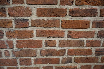 Textured red color brick wall background closeup 