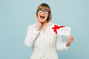 Employee business woman 50s wears white classic suit glasses formal clothes hold face, store gift certificate coupon voucher card isolated on plain light blue background. Achievement career concept.