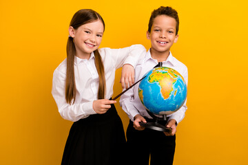 Fototapeta premium Photo of positive cheerful preteen schoolchildren wear white shirts learning geography isolated yellow color background