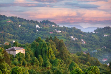 Fototapeta na wymiar Beautiful tourist landscape of a mountainous area with a small house and a colorful sky. Mountains of Georgia.