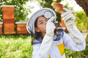 Girl learning to be beekeeper with magnifying glass