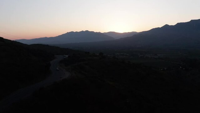 Low aerial shot flying above a mountain road for Ojai Valley's famous "Pink Moment" in California. 4K